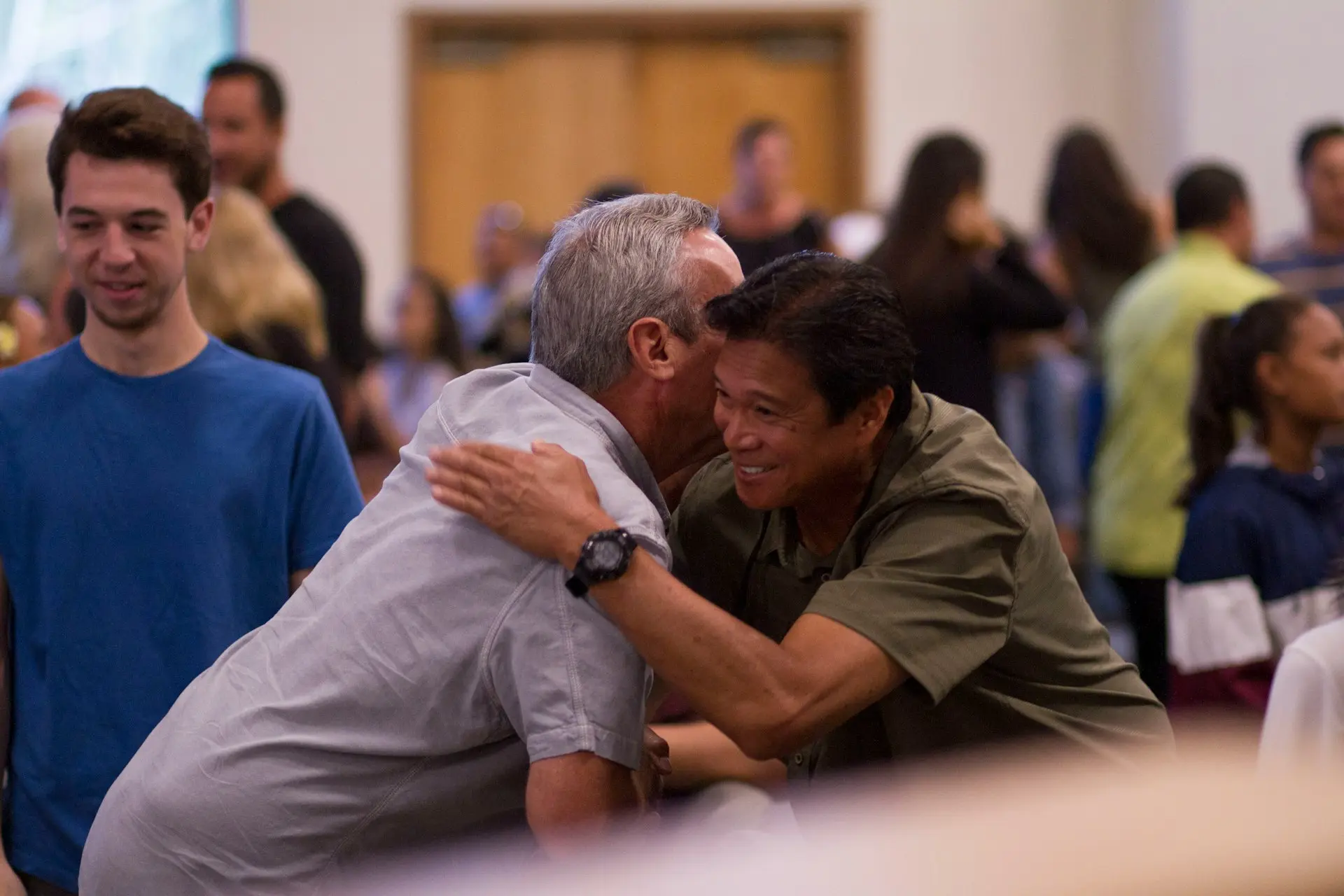 two men hugging on focus photography